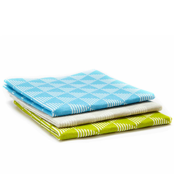 Three stacked folded cloths in blue, grey and green