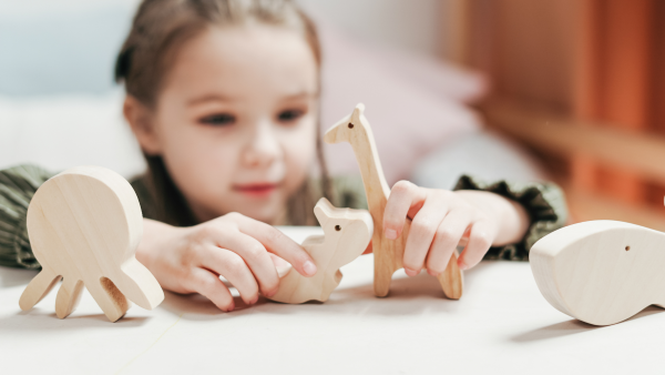 child playing with wooden animal toys