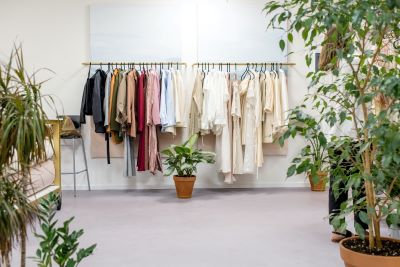 preloved clothing on a rack with plants nearby