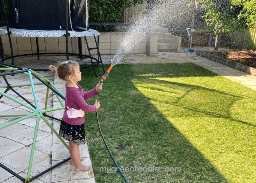 Girl watering lawn with hose