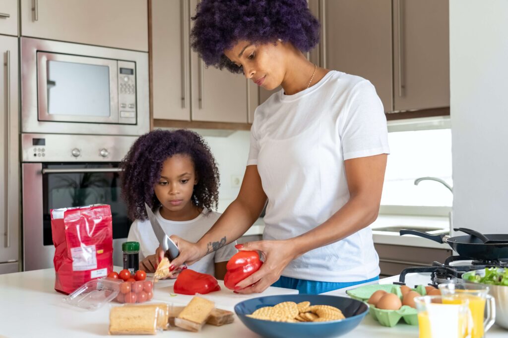 Woman and child preparing food in kitchen