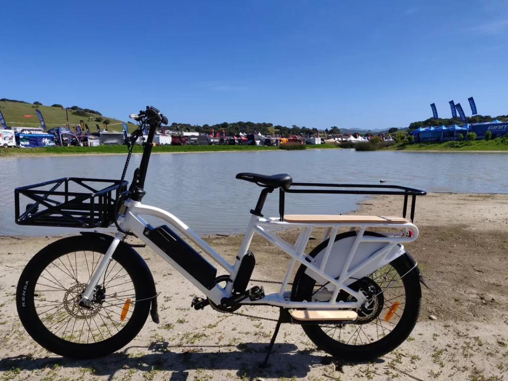 Photo of white electric bike parked next to a lake